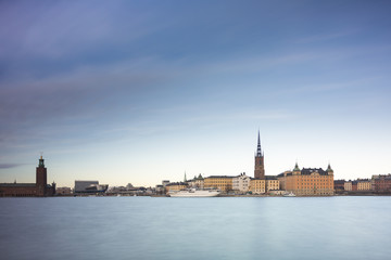 Fototapeta na wymiar Beautiful scenic panorama of the Old City (Gamla Stan) cityscape pier architecture with historic town houses with colored facade in Stockholm, Sweden. Creative long time exposure landscape photography