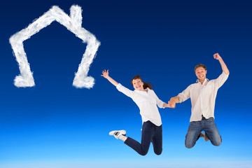 Fototapeta na wymiar Composite image of couple jumping and holding hands against blue sky