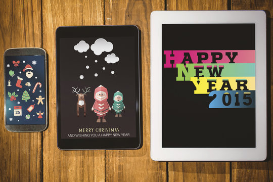 Christmas graphics against tablet and smartphone on desk