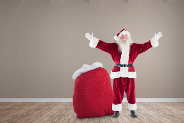 Happy santa with sack of gifts against room with wooden floor