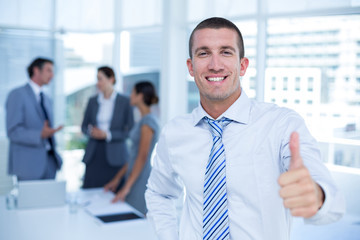 Smiling businessman gesturing thumbs up