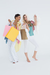 Smiling young women standing with shopping bags