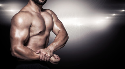 Fototapeta na wymiar Portrait of a bodybuilder man flexing muscles against lens flare