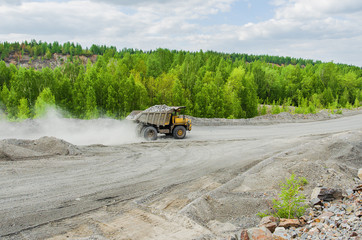 BelAZ truck transports ore on a dirt road