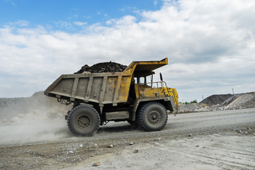 BelAZ truck transports ore on a dirt road
