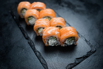 Philadelphia sushi rolls on dark background. Eastern traditional restaurant menu. Delicious food