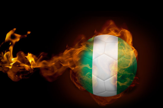 Composite image of fire surrounding nigeria ball against black