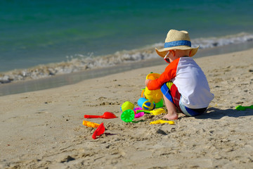 Two year old toddler playing on beach