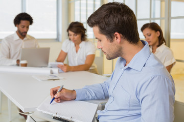 Obraz premium Businessman reading document with colleagues in meeting at office