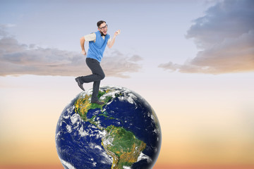 Geeky hipster dancing and smiling against beautiful orange and blue sky