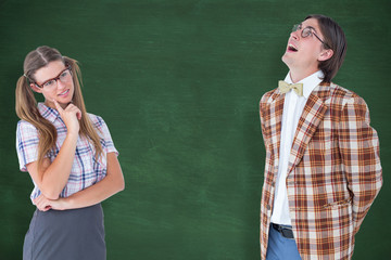 Thoughtful geeky hipsters against green chalkboard