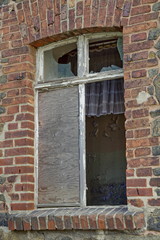 Fototapeta na wymiar Broken window of a brickhouse