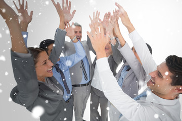 Business people raising their arms  against snow