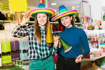 Obraz na płótnie Canvas Playfully girls in colorful party hats in festive decoration sho
