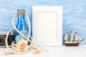 photo frame, retro camera, seashells and old bottle on blue boards background. summer vacation background