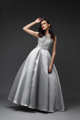 Fototapeta na wymiar Young elegant woman in long silver dress.