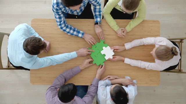 Hipster business successful teamwork concept, business people group assembling jigsaw puzzle, top 

view