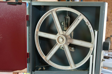 Detailed image of an opened band saw in a little carpentry shop.