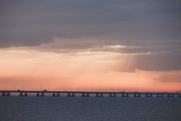 Orange sunset over the bridge silhouette. Ocean hrizon sunny landscape