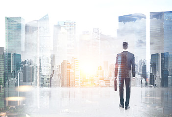 Businessman with a suitcase against a cityscape