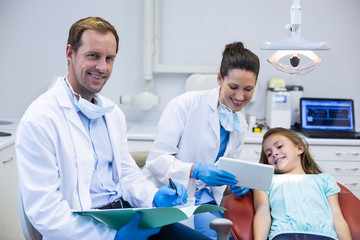 Dentist showing digital tablet to young patient