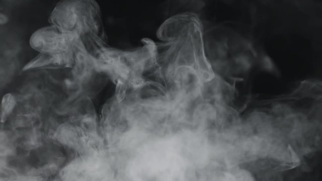 slow motion vapor steam rising over black background
