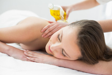 Obraz na płótnie Canvas Beautiful woman enjoying oil massage at beauty spa