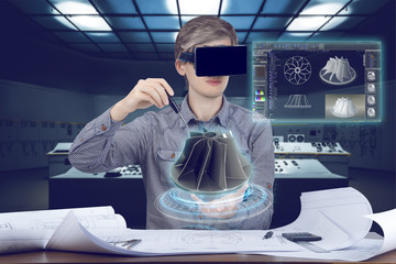 Futuristic cad engineer’s workplace. Male / man wearing shirt and vr glasses touches with screwdriver 3d model of turbine and looking at virtual screen analyzing data for mechanic industry - obrazy, fototapety, plakaty