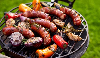 Wall murals Grill / Barbecue Grilled sausages and vegetables on a grilled plate, outdoor. Grilled food, bbq