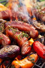Grilled sausages and vegetables on a grilled plate, outdoor. Grilled food, bbq