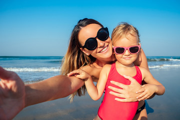 charming little girl and her mom are photographed on the phone