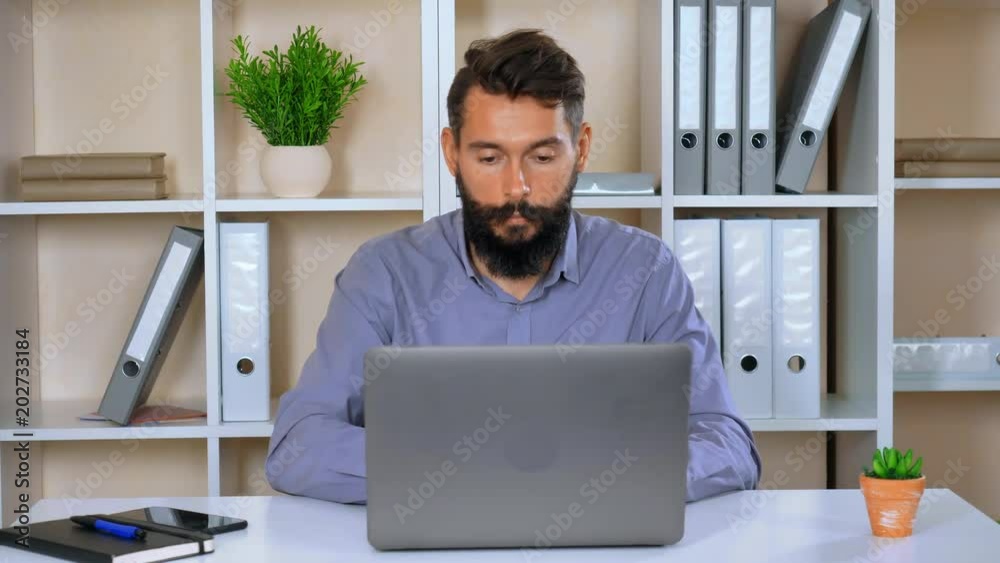 Poster bearded hipster working on laptop in contemporary office. handsome worker with beard and mustache su