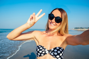 smiling and beautiful woman doing selfie on vacation