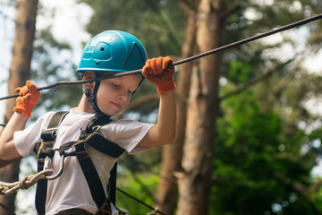 boy at climbing activity in high wire forest park