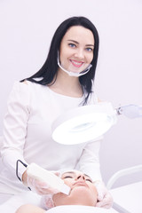 Ultrasonic cleaning of the face. Young girl beautician. Modern equipment