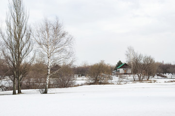 March rustic landscape with bare trees and cottage in Kolomenskoye park, Moscow, Russia