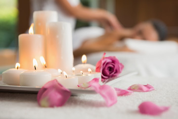 Obraz na płótnie Canvas Candles and rose petals on massage table