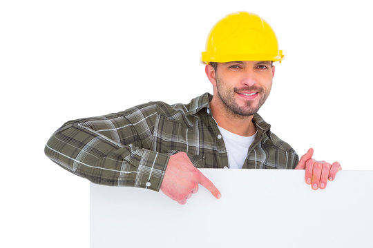 handyman holding and pointing at blank board 
