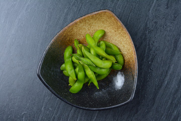 Edamame, or edamame bean in black plate on black marble table