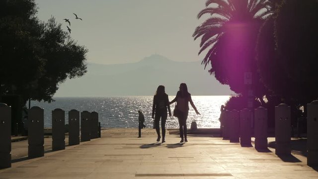 Women walking on an alley near the sea