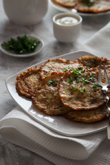 Vegetable pancakes with parsley on a white plate