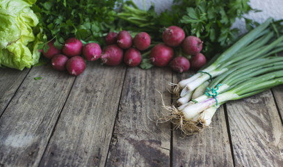 Radish and spring onions on old wooden table