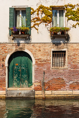 Fototapeta na wymiar Facade of an old house on a canal in Venice, Italy