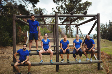 Fit people sitting on the obstacle couse in bootcamp