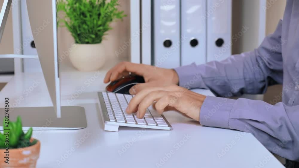 Aufkleber manager working on computer. unrecognizable busineess man sitting at the desk with flower pot folders and pc display