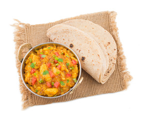 Indian Cuisine Spicy Fried Aloo Also Know as Potato Fry, Potato Curry, Aloo Masala or Alu Masala Served with Indian Bread, Roti or Chapati isolated on White Background