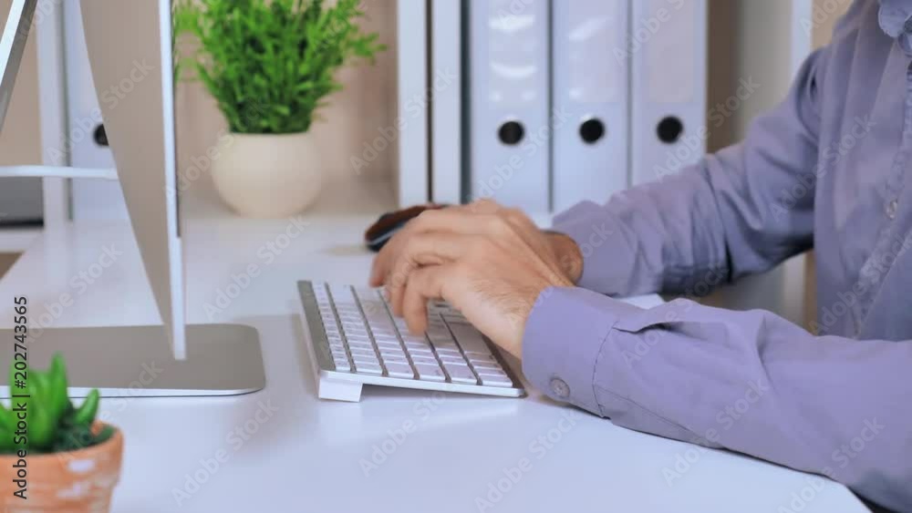 Poster close up details business man sitting at the white desk in modern office typing on keyboard. unrecognizable employer working on computer at the workspace