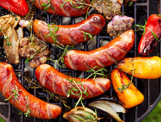 Saucisses et légumes grillés sur une assiette grillée, vue de dessus, en plein air. Grillades, barbecue