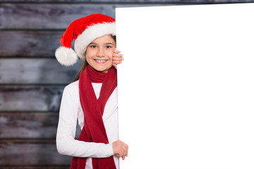 Festive little girl showing card against blurry wooden planks