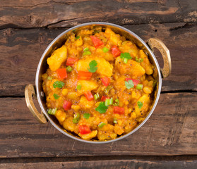 Indian Cuisine Spicy Fried Aloo Also Know as Potato Fry, Potato Curry, Aloo Masala or Alu Masala on Wooden Table